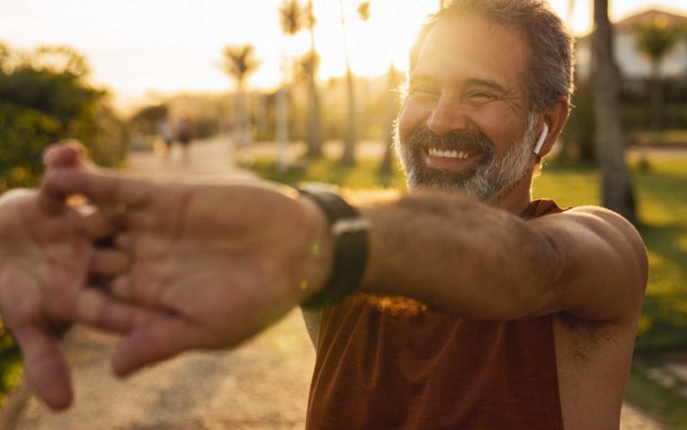 Imagem de homem sorrindo e praticando exercício físico, um dos benefícios da citrulina.